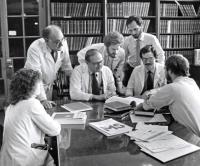 Dr. Lewis P Rowland and colleagues looking at the books and talking